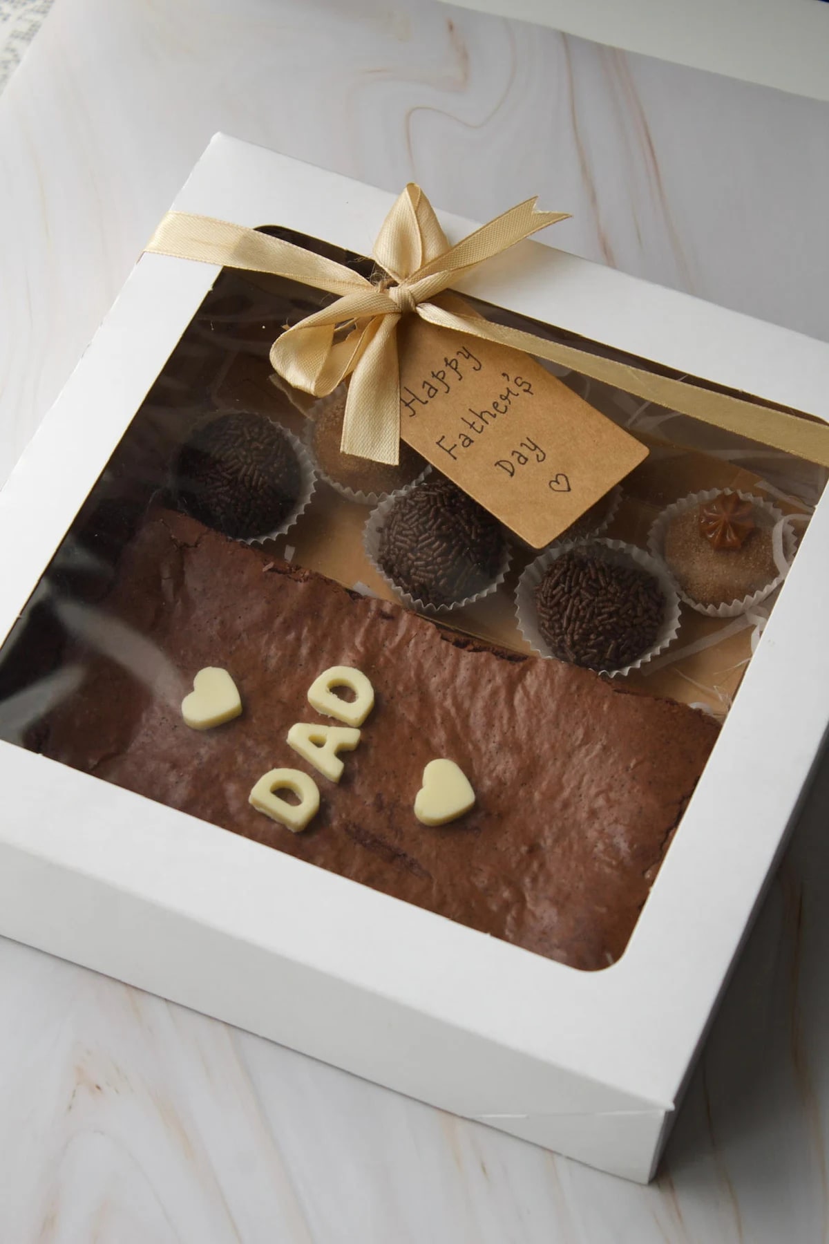 White Joyful Bakehouse gift box with a chocolate brownie and assorted brigadeiros
