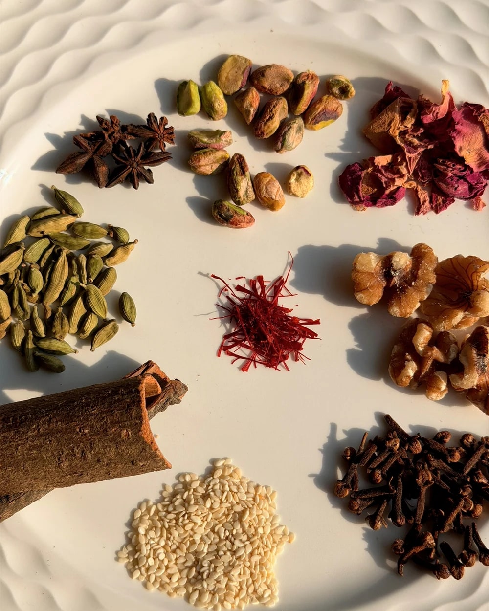 Cardamom, saffron, pistachios, rose petals and spices arranged together