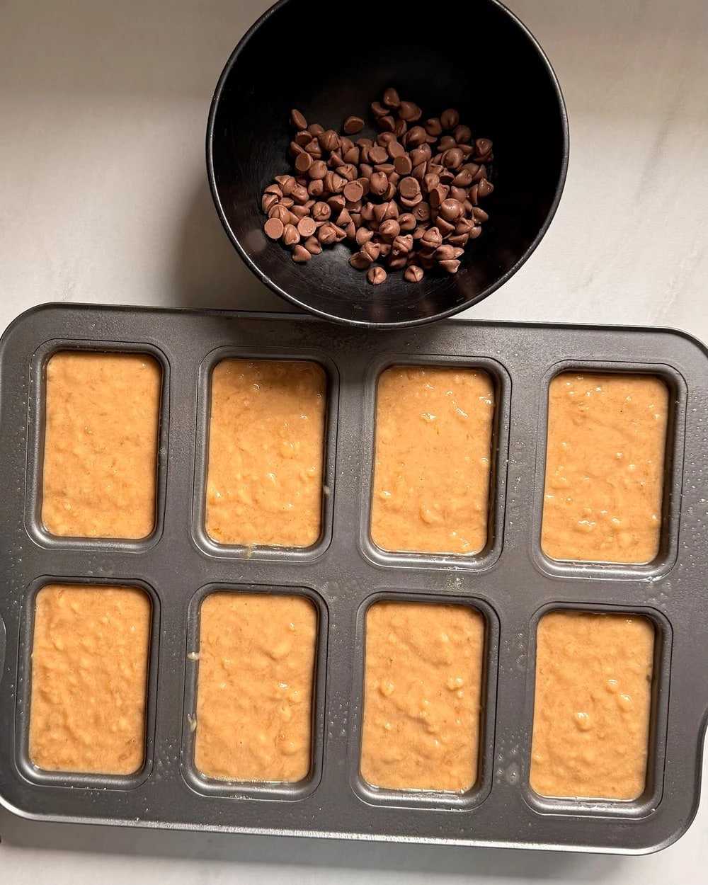 Mini loaf tins filled evenly with batter before baking